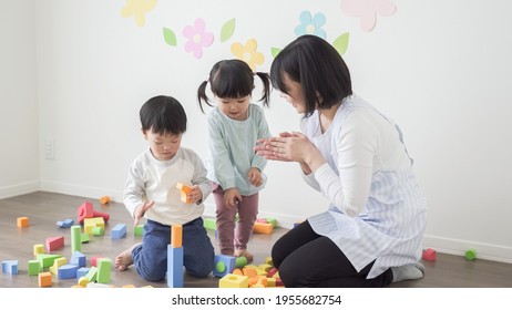 A Child Playing With A Teacher In A Nursery School