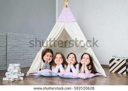 Child playing with a teepee