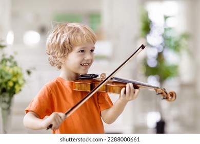 Child playing violin. Remote learning from home. Arts for kids. Little boy with musical instrument. Video chat conference lesson. Online music tuition. Creative children play song. Classical education - Powered by Shutterstock