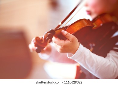 Child Playing The Violin In A Room