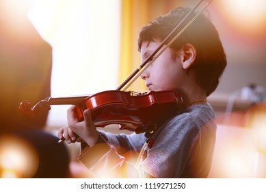 Child playing the violin in  room - Powered by Shutterstock