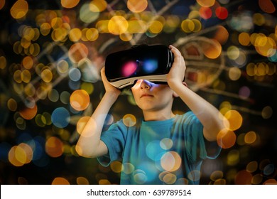 Child Playing With A Virtual Reality Headset. Young Boy Wearing And Learning With A VR Goggles.