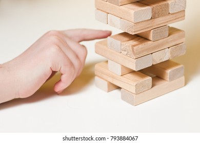 The Child Plays In Board Game Falling Tower Of Wooden Blocks