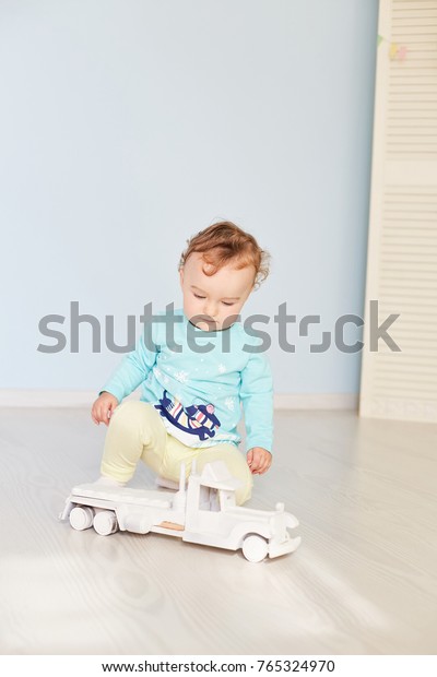 child plays with a car in\
the studio