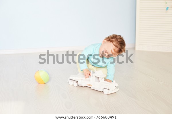 child plays with a car in\
the studio