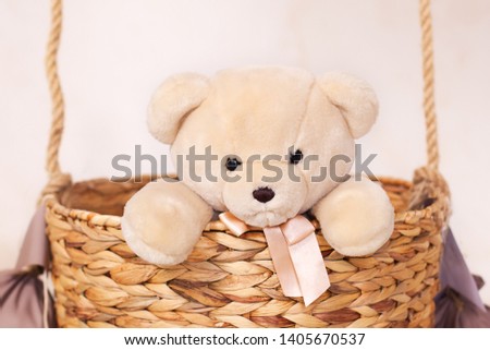 A child plays with a plush bear. Kids toys. Teddy sitting in the balloon basket, aerostat. Retro teddy bear. Toy teddy bear alone in a basket. Sitting toy bear on the background of Wallpapers