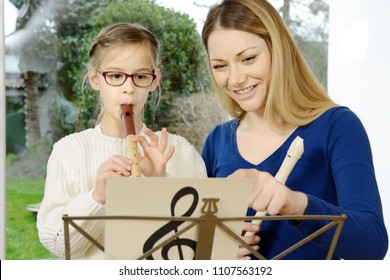 Child Plays Recorder As An Instrument In Music Class With Music Teacher