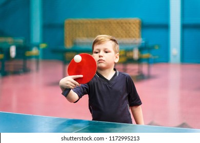 the child plays table tennis indoors