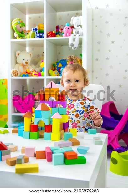 The child plays with toys in the room. Selective\
focus. Baby.