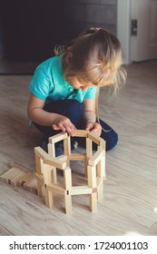 A Child Plays With A Wooden Constructor. Home Games During Quarantine. Early Childhood Development