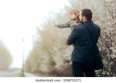 Child With Pointed Finger Showing Something To Her Dad. Curious Daughter Asking Questions For Her Father To Answer While Walking In Springtime Bloom
