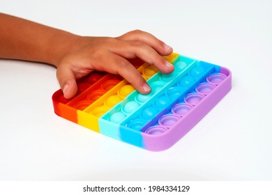 Trendy toy antistress. Anonymous child with colorful poppit game