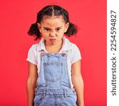Child, portrait or angry face on isolated red background in emoji tantrum, behavior or stubborn studio problem. Mad, annoyed or frustrated little girl and sulking, grumpy or anger facial expression