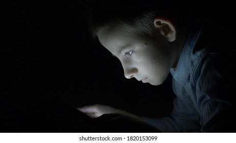 Child Portrait Looking At Tablet Screen In Dark