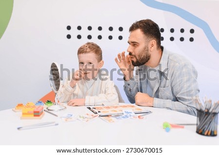 Child practicing articulation exercises with a speech therapist. Improving communication skills and addressing developmental needs in a bright room