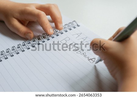 Child practicing handwriting in notebook - close-up educational series