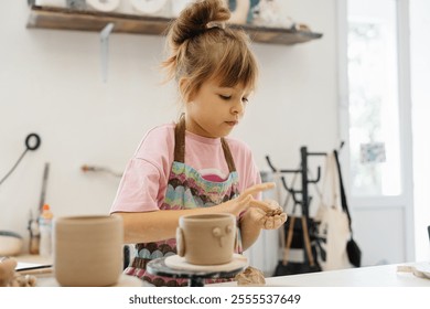 child practicing pottery in a creative studio during the day