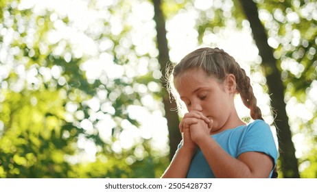 child pray. young gratitude a god religion concept. little lifestyle girl in nature outdoors praying dreams of happiness to god. praise worship freedom concept. kid praying in the forest - Powered by Shutterstock