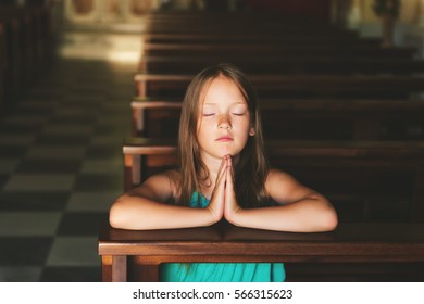 little girl praying in church