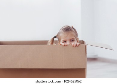 Child preschooler boy playing inside paper box. Repairs and new house concept.