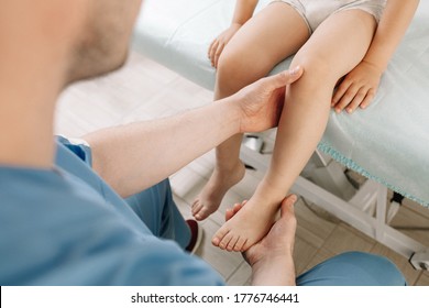A child as prescribed by a doctor with an osteopathic pediatrician. Examination and correction of the legs. The doctor holds the child foot in his arms. In the clinic. - Powered by Shutterstock