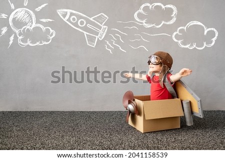 Child pretend to be pilot. Kid having fun at home. Happy child dreaming about travel. Funny kid playing. Summer vacation and travel concept