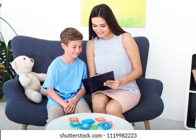 Child psychologist working with boy in office