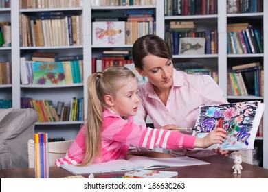 Child psychologist working with little girl's pictures - Powered by Shutterstock