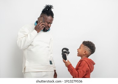 The Child Pulls Dad's Hand, He Wants To Play Box, Dad Is Busy Talking On The Phone.  The Social Problem Of Busy Parents