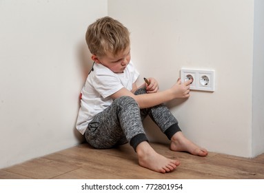 Child Put Finger In Socket.  Dangerous Situation At Home. Child Playing With Electrical Socket.