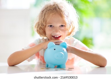 Child Putting Coin In Piggy Bank. Kids Learn About Money. Savings And Investment. Little Boy Saving Cash. Wealth Growth For Young Family With Children. Budget Planning At Home.