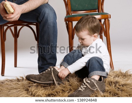 Foto Bild Kleiner Junge setzt kleines Papierschiff ins Wasser