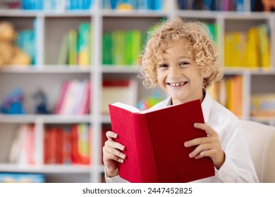 Child reading book. Kids read. Little boy at a colorful bookshelf doing homework for school. Student with books. Early education and development. Home library for children. Preschool kid study. - Powered by Shutterstock