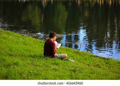 A child reads a book on the nature - Shutterstock ID 456643960