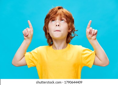  child with red hair points up with index finger Copy Space - Powered by Shutterstock