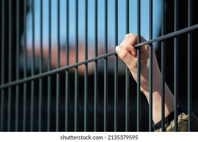 Child Refugee Hand Holding A Metal Fence. Social Problem Of War Migrants.