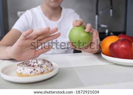 Child refuses to eat unhealthy sweets and choose fruits for dessert. Healthy eating and active lifestyle concept