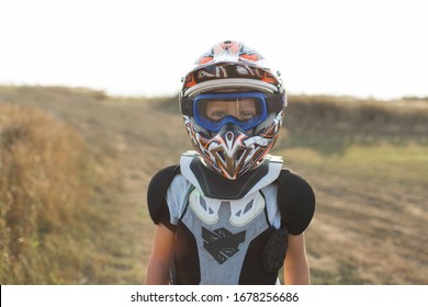 Child Rider On Motorcycle. Small Biker Dressed In A Protective Suit And Helmet. The Kid Is Engaged In Motocross