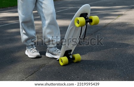 A child rides a skateboard in the school yard. Skateboarding on a sports field in the city.