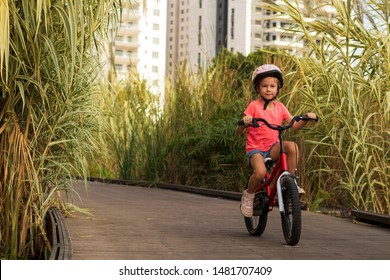 Child Riding Bike. Kid On Bicycle In Sunny Park. Little Girl Enjoying Bike Ride On Her Way To School On Warm Summer Day. Preschooler Learning To Balance On Bicycle In Safe Helmet. Sport For Kids