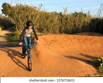 Child Riding A Bmx Bike On A Pump Track