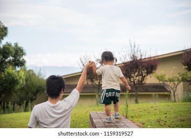 Child Riding In High Places With Help Of Elder.