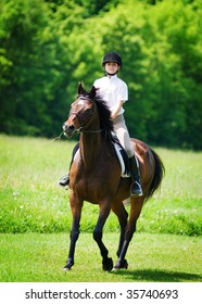 Child Riding A Horse Through A Field