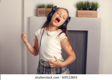 Child Rocker Singing And Dancing With Headphones. The Concept Of Lifestyle And Music.