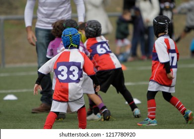 Child rugby players run towards the adversary
