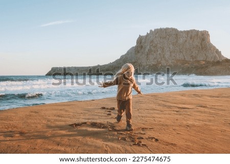 Child running on sandy beach kid girl 4 years old playing family travel lifestyle vacations outdoor