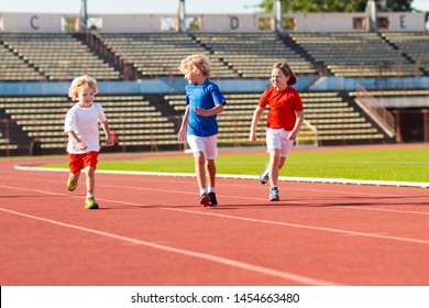 Child Running In Stadium. Kids Run On Outdoor Track. Healthy Sport Activity For Children. Little Girl And Boy At Athletics Competition Race. Young Athlete Training. Runner Exercising. Jogging For Kid.