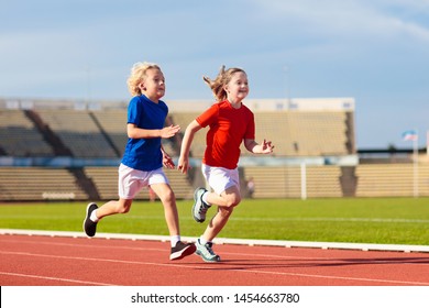 Child Running In Stadium. Kids Run On Outdoor Track. Healthy Sport Activity For Children. Little Girl And Boy At Athletics Competition Race. Young Athlete Training. Runner Exercising. Jogging For Kid.