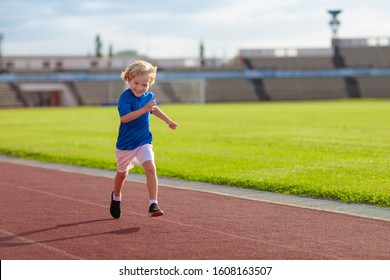 Child Running In Stadium. Kids Run On Outdoor Track. Healthy Sport Activity For Children. Little Boy At Athletics Competition Race. Young Athlete In Training. Runner Exercising. Jogging For Kid.