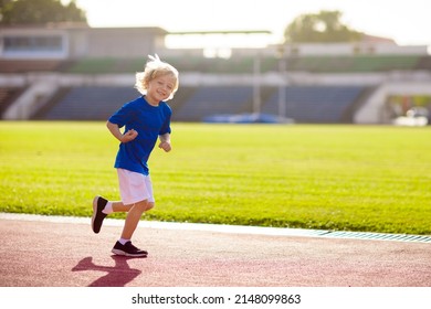 Child Running In Stadium. Kids Run On Outdoor Track. Healthy Sport Activity For Children. Little Boy At Athletics Competition Race. Young Athlete In Training. Runner Exercising. Jogging For Kid.